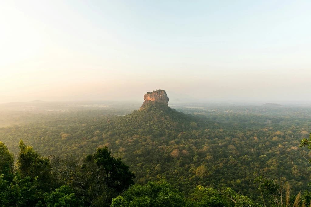Sigiriya rock fortress rising above jungle at golden hour